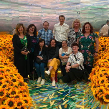 Group photo of the team in the sunflower room at Van Gogh Alive.